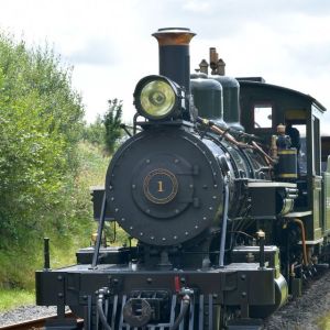 a steam engine is sitting on a train track