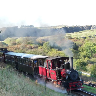 a steam train on a track with smoke coming out of it