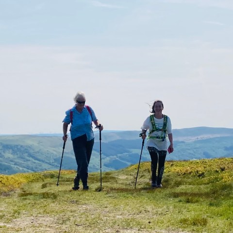 a man standing on top of a grass covered hill