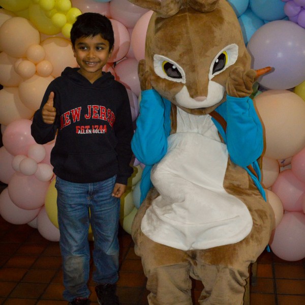 a large brown teddy bear sitting on top of a pile of stuffed animals