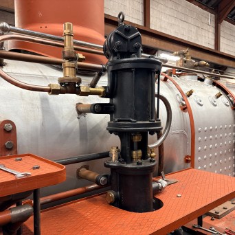 Industrial machinery with pipes and bolts in a workshop setting.