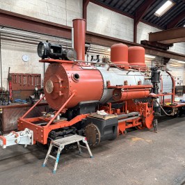 Steam locomotive being restored in a workshop.