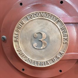 Bronze Baldwin Locomotive Works plaque on red surface.