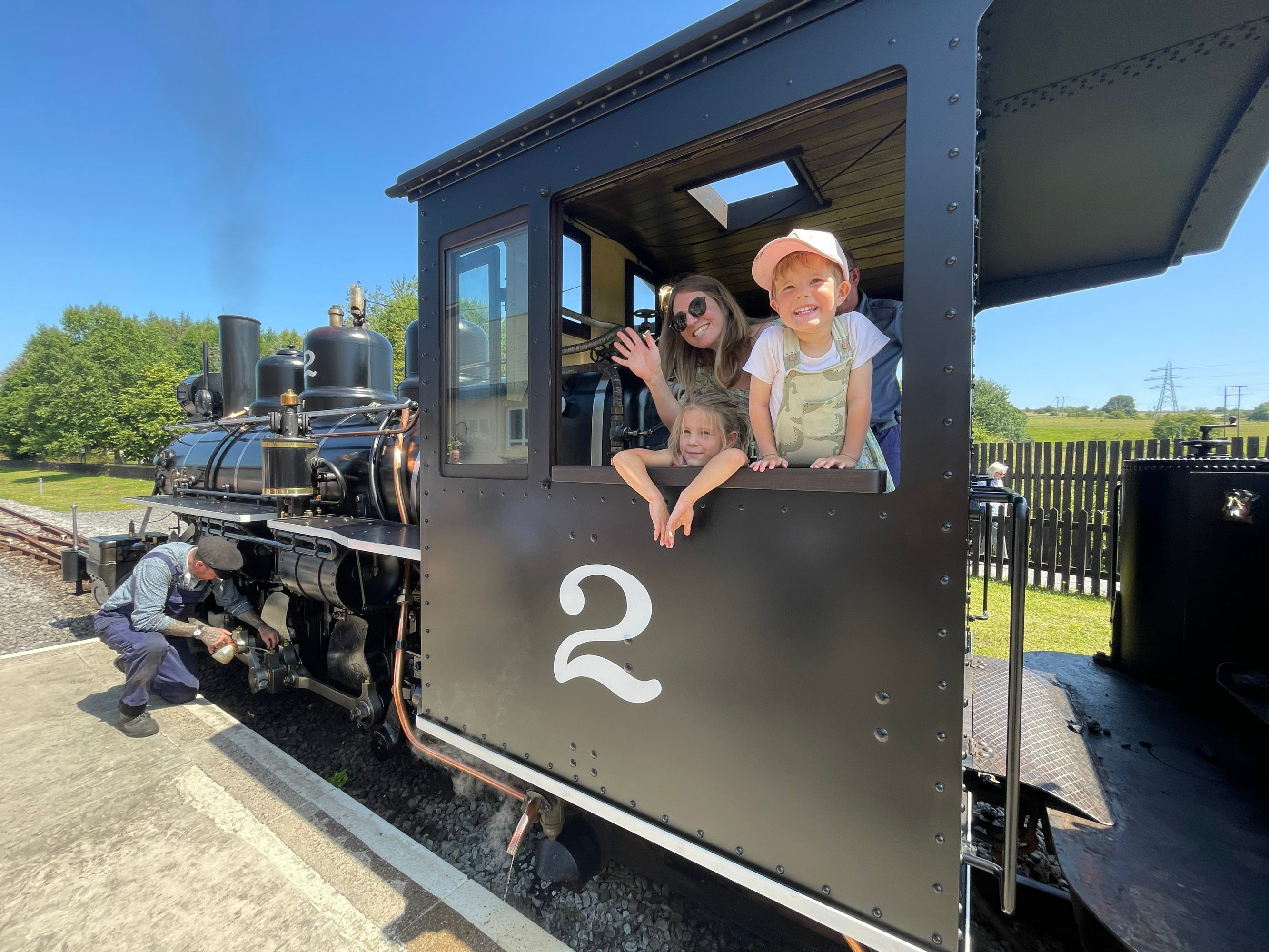 Smiling family in a train cabin with the number 2.