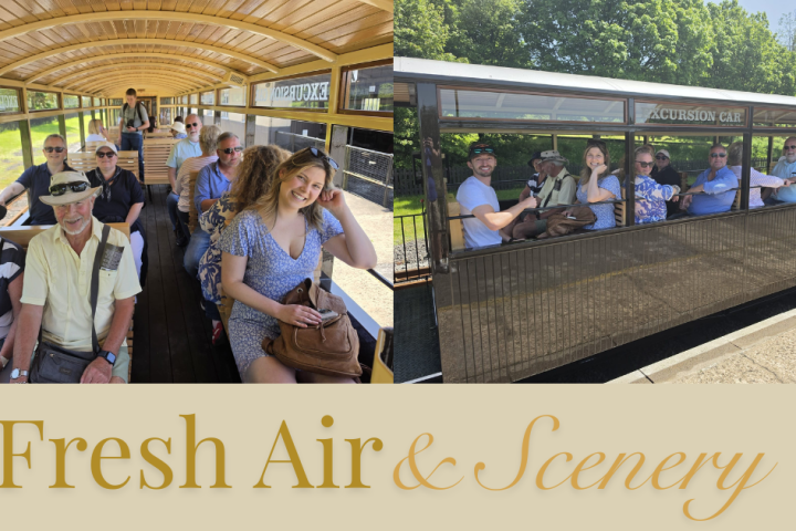 People sitting in open carriage on vintage train, enjoying sunny day.